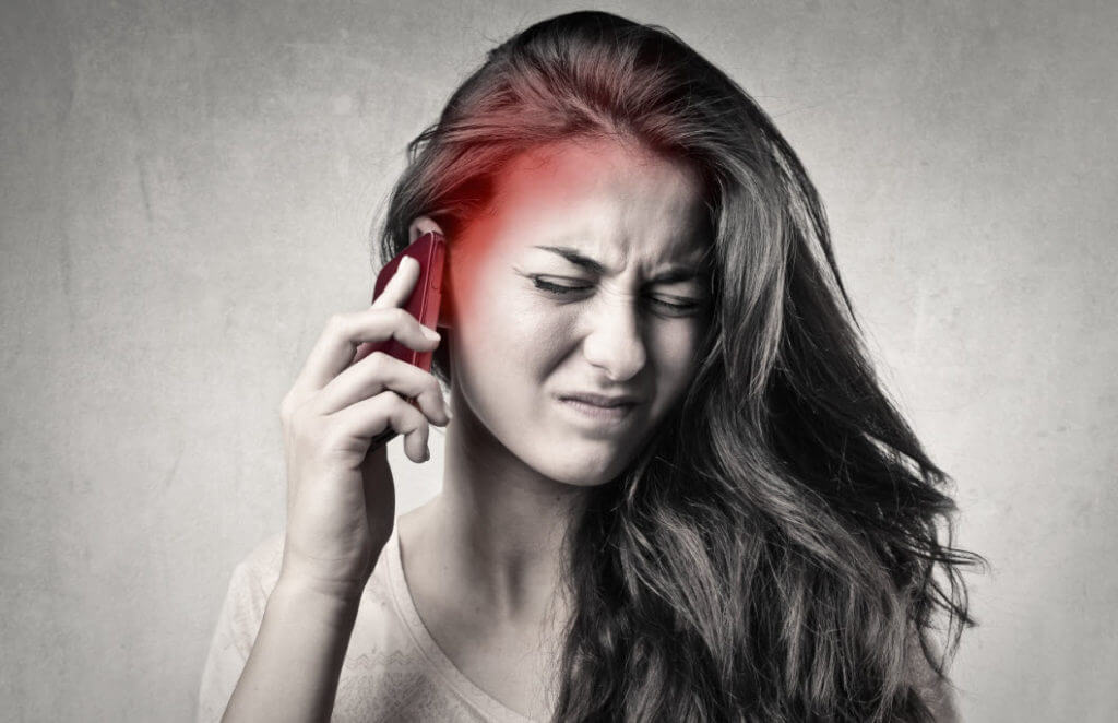 Girl with phone and headache Protect Your Family from EMF Pollution